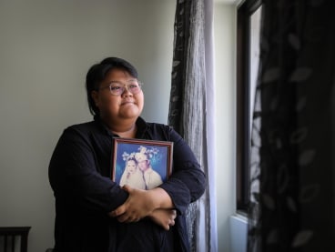 Gen Z Speaks writer Qistina Hatta holds a wedding photograph of her father and late mother.