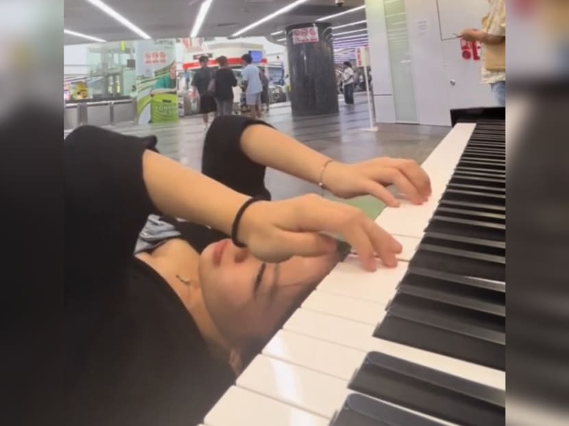 Ms Jovanna Yam, 21, executing a stunt while playing a piano in public at Orchard MRT Station.