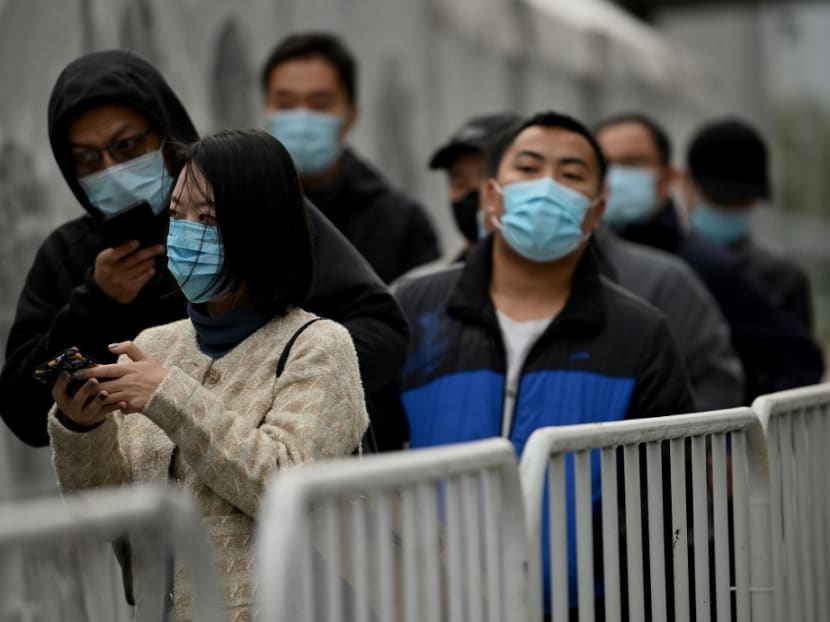 This file photo taken on Nov 1, 2021 shows people queueing for swab test for Covid-19 coronavirus in Beijing.
