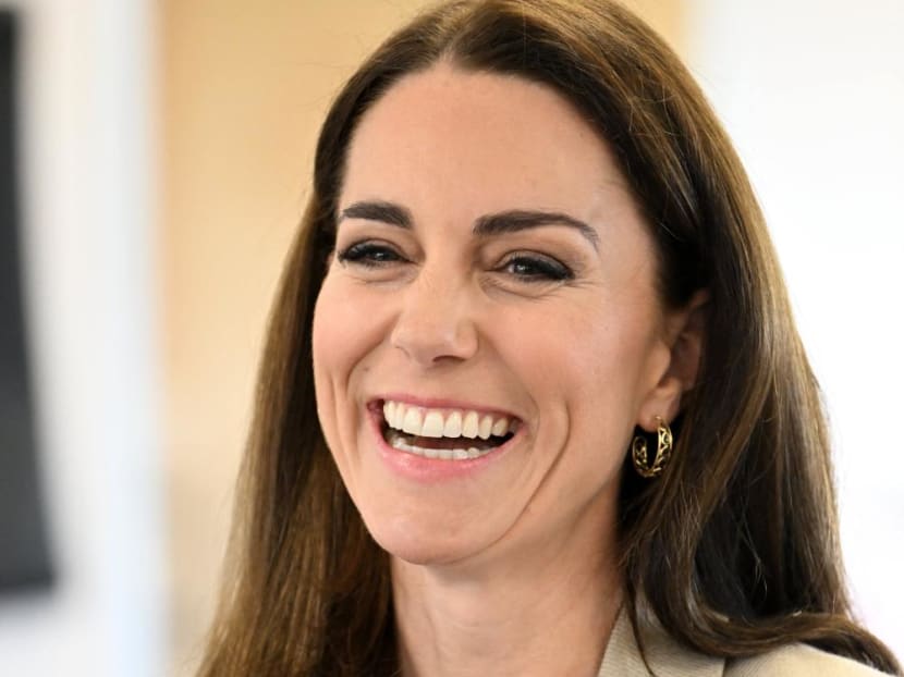 Britain's Catherine, Princess of Wales smiles as she speaks with staff members during a visit to The Baby Bank in Windsor, west of London on April 24, 2023.