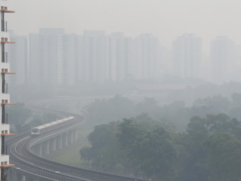 A shrouded view of an MRT train and housing blocks in Jurong due to the haze in October 2015.