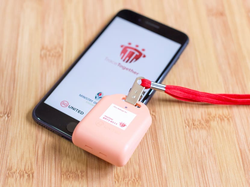 A smartphone displaying the TraceTogether mobile application and a TraceTogether token. The public uses either of these to gain entry into malls, restaurants and other venues. A smartphone displaying the TraceTogether mobile application and a TraceTogether token. The public uses either of these to gain entry into malls, restaurants and other venues.