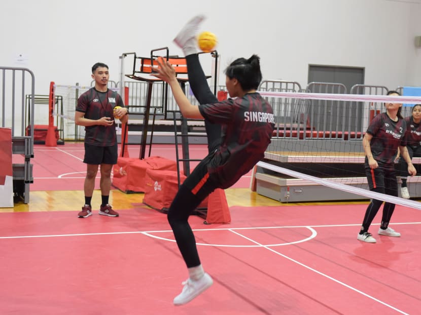Nur Ezzaty Putri Rohaizat (foreground), 15, performs the backstroke spike during a practice match.