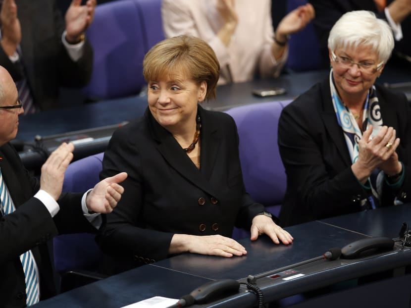 Members of the parliament applaud after German Chancellor Angela Merkel was re-elected during a meeting of the German federal parliament. Photo: AP