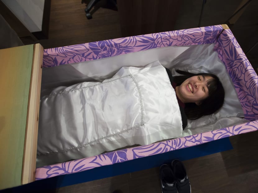 Ms Miwa Okamoto lies down in a coffin at a Coffin Experience cafe in Tokyo. Photo: Bloomberg