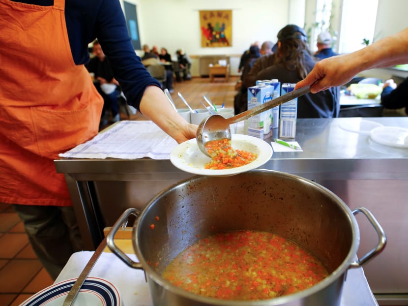 Volunteers dish out vegetable soup for people in need at the soup kitchen "Kana" in a poor district of the city of Dortmund, western Germany. Volunteers dish out vegetable soup for people in need at the soup kitchen "Kana" in a poor district of the city of Dortmund, western Germany.