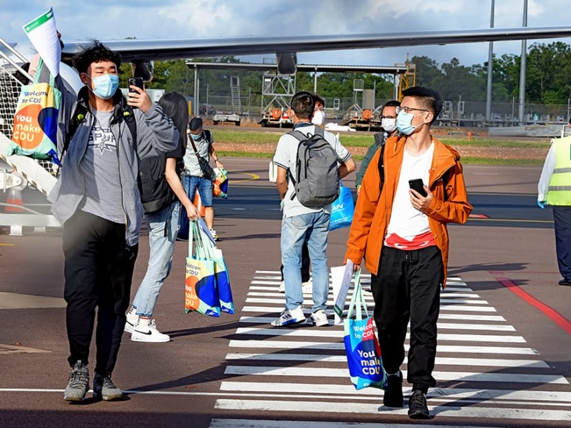 This handout picture taken on Nov 30, 2020 and released by Charles Darwin University shows foreign students disembarking from an international flight at Darwin Airport in Darwin.