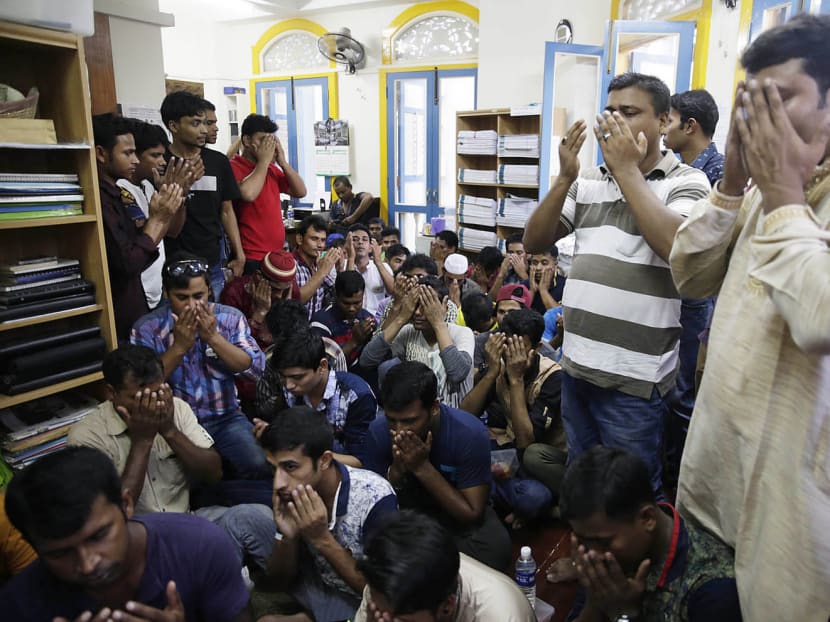 Bangladeshi workers here gathered yesterday for a prayer session for the victims of the Dhaka attack. Photo: Wee Teck Hian