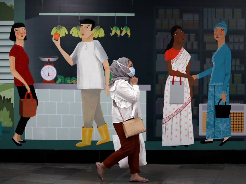 A woman wearing protective mask passes by a mural at a Mass Rapid Transit station, following the outbreak of the coronavirus in Kuala Lumpur, Malaysia.