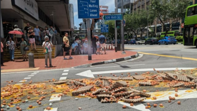 数百个鸡蛋从货车掉落  染黄牛车水路面
