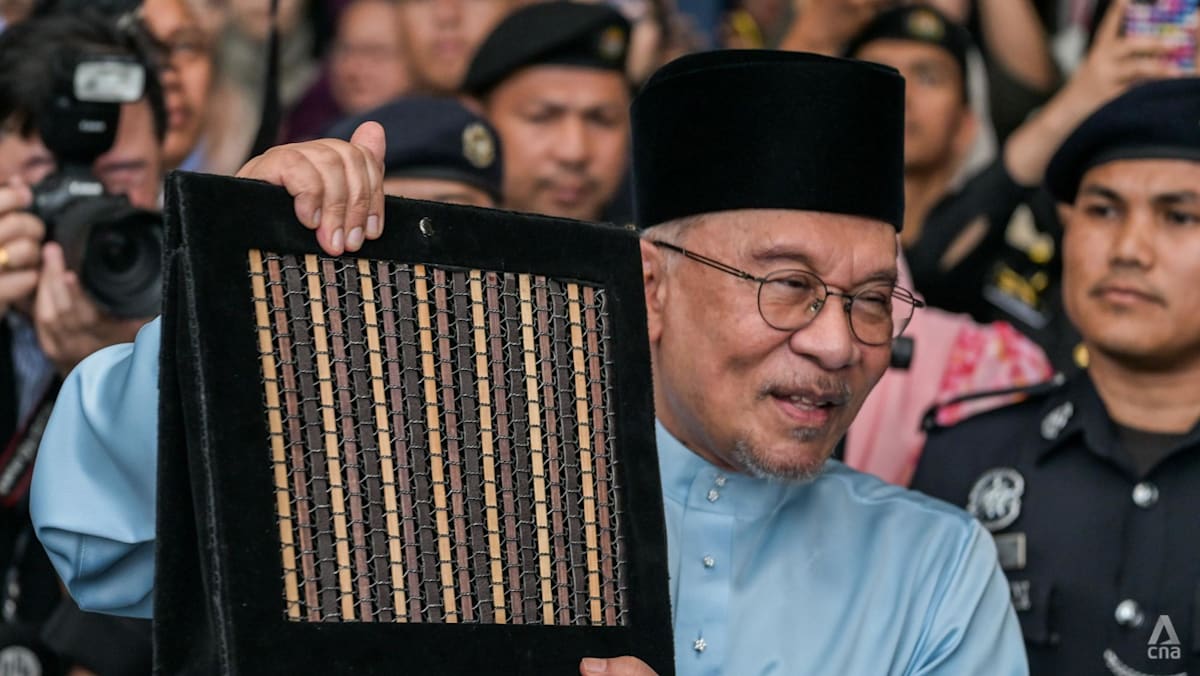 Malaysia Prime Minister Anwar Ibrahim, who is also the finance minister, showing the 2027 budget booklet at the Ministry of Finance in Putrajaya on Oct 9, 2026. (Photo: CNA/Fadza Ishak)