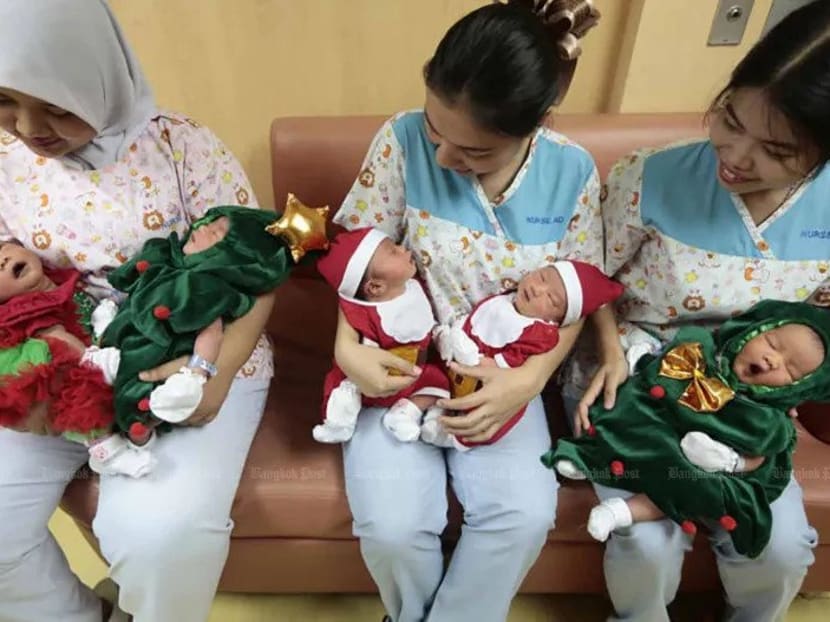 Nurses hold newborns dressed in Christmas costumes at a hospital in Bangkok.