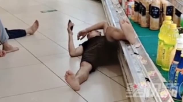 天气炎热到超市乘凉 中国男子把脚放在饮品冷藏柜上