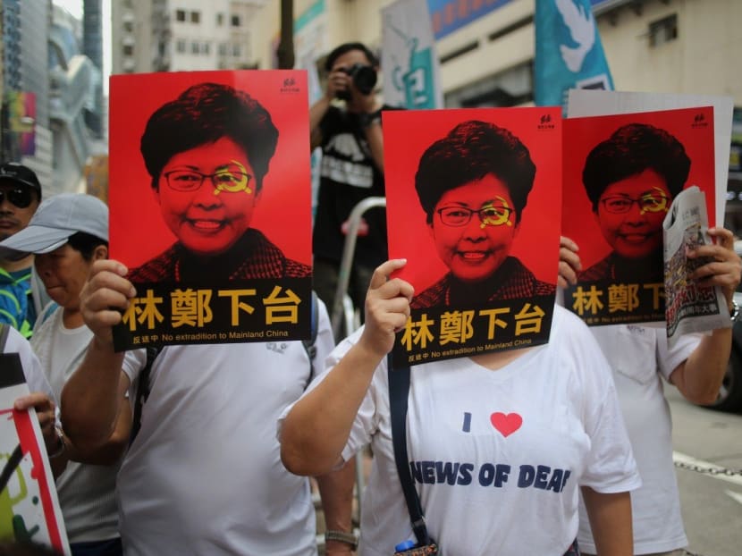 Protesters cover their faces with posters of Hong Kong Chief Executive Carrie Lam during the march from Causeway Bay to the government headquarters in Admiralty. Protesters cover their faces with posters of Hong Kong Chief Executive Carrie Lam during the march from Causeway Bay to the government headquarters in Admiralty.