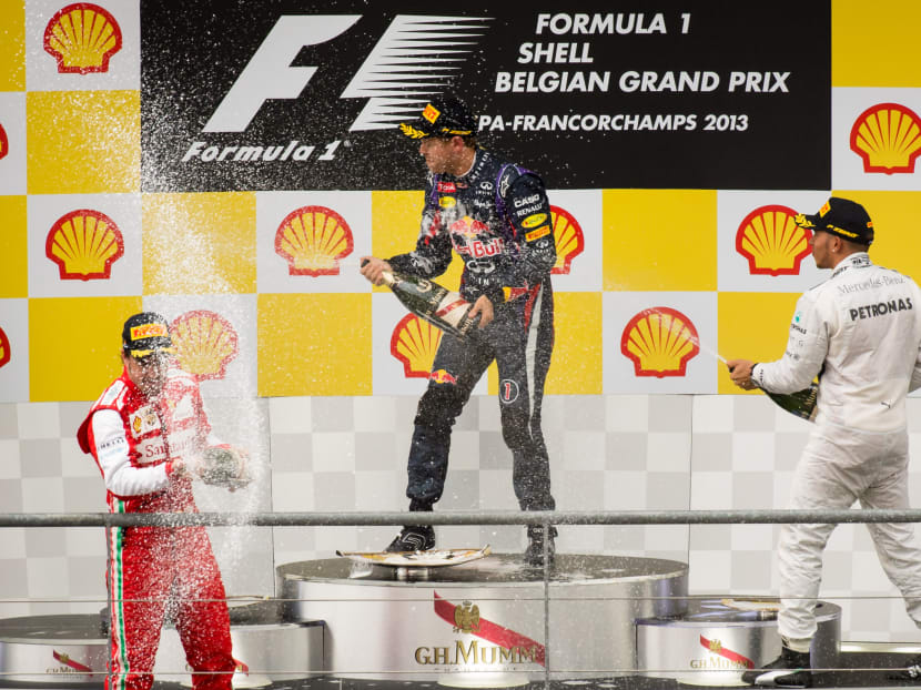 Winner, Red Bull driver Sebastian Vettel of Germany, center, Ferrari driver Fernando Alonso of Spain, left, who finished second,  and third placed Mercedes AMG driver Lewis Hamilton of Britain, right, spray champagne as they stand on the podium after the Belgian Formula One Grand Prix in Spa-Francorchamps, Belgium, Sunday, Aug. 25, 2013. Photo: AP