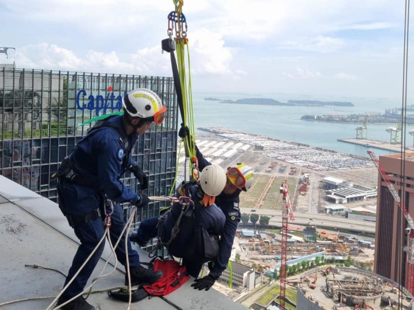 Members of the Disaster Assistance and Rescue Team rescue two workers who were stranded on a gondola at Capital Tower on March 20, 2023. 