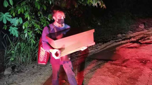 道路崎岖灵车难行 马国丧女父半夜抱棺走一小时