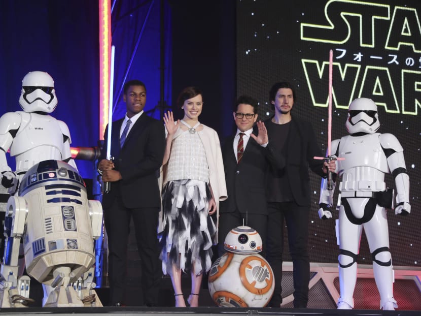 In this Dec 10, 2015 photo, director J J Abrams, third right, and actors, John Boyega, second left, Daisy Ridley, third left, and Adam Driver, second right, pose for photos during the Japan Premiere of their latest film "Star Wars: The Force Awakens" in Tokyo. Photo: AP