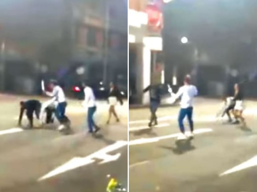 A man wearing a white shirt and blue pants was seen brandishing a long metallic object at another man.