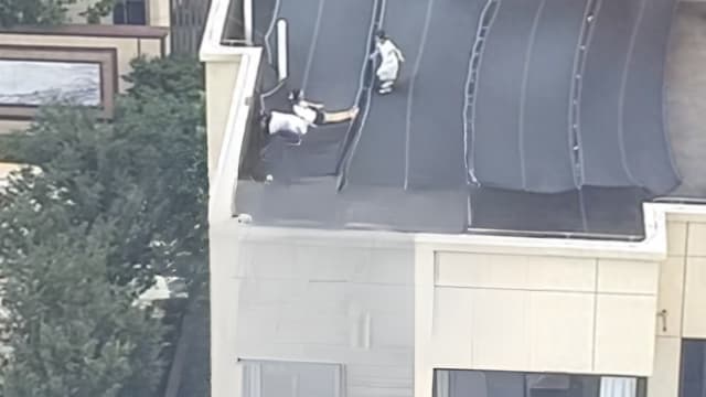 遮阳网竟成“空中滑梯” 中国住宅楼顶孩童高空玩耍