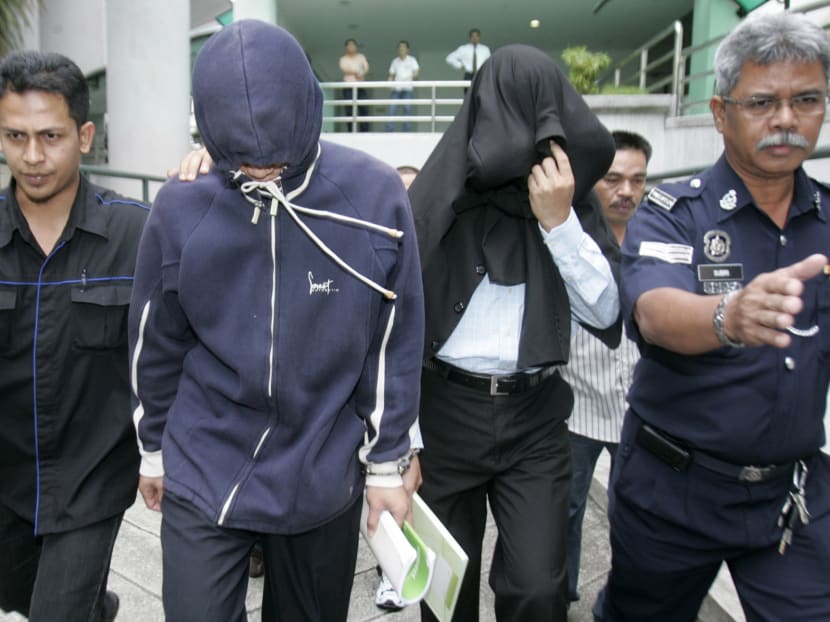 Policemen Azilah Hadri and Sirul Azhar Umar arrive at the courthouse in Shah Alam outside Kuala Lumpur in this January 15, 2009 file photo.