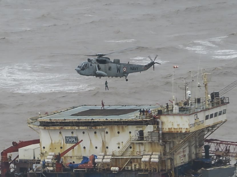 Stranded workers from a barge, which had gone adrift amidst heavy rain and strong winds due to Cyclone Tauktae, are airlifted by naval personnel on an Indian Navy Seaking helicopter during an evacuation operation in the Arabian sea on May 18, 2021.
