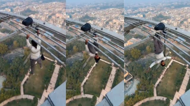 印度男子在86米高楼耍特技 徒手抓杆转圈还倒挂