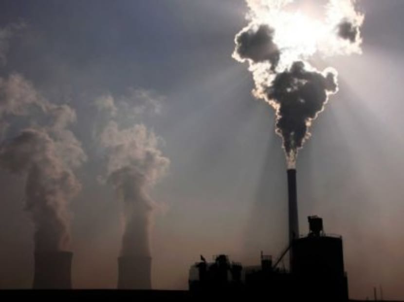 A coal-burning power plant can be seen behind a factory in the city of Baotou on Oct 31, 2010. Photo: Reuters