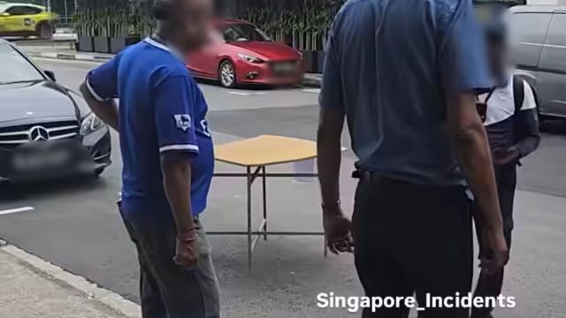两男子疑搬桌霸占车位 被执法人员逮个正着
