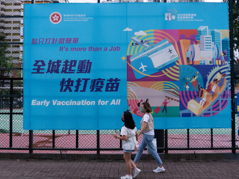 People walk past a government banner encouraging the public to take the Covid-19 vaccine in Hong Kong on Aug 15, 2021.