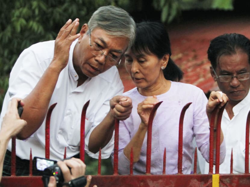 In this Nov 13, 2010, file photo, Myanmar's pro-democracy leader Aung San Suu Kyi, centre, speaks with aide Htin Kyaw, left, as she addresses her supporters from the front gates of her home after her release from house arrest in Yangon, Myanmar. Photo: AP