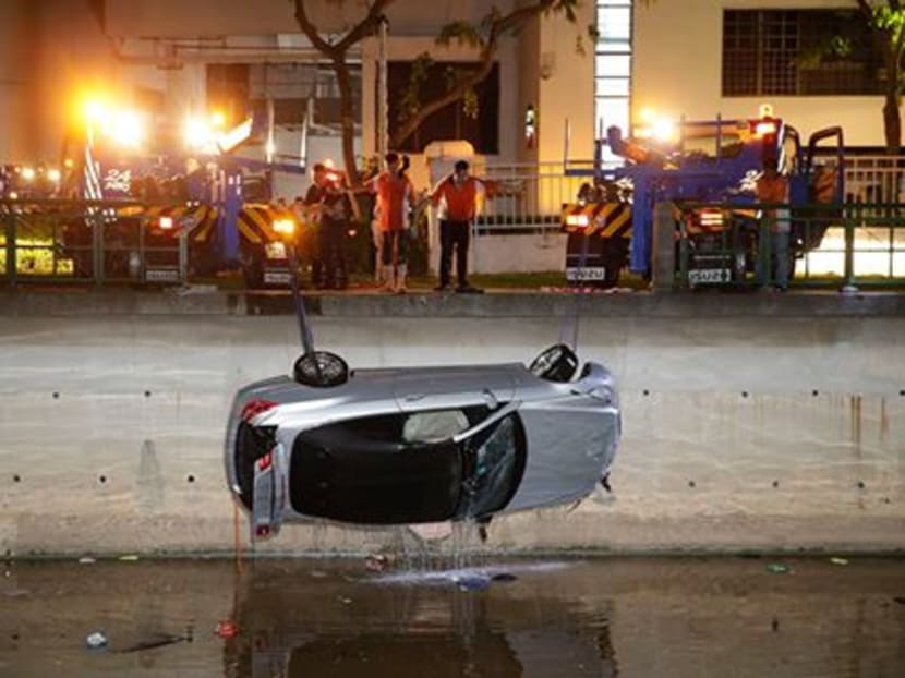 Recovery trucks hoist up a submerged car out of the Alexandra Canal near Valley Point Shopping Centre on Jan 25, 2016. The car plunged into the Alexandra Canal, killing a mother and daughter who were in the vehicle. Photo: Wee Teck Hian/TODAY