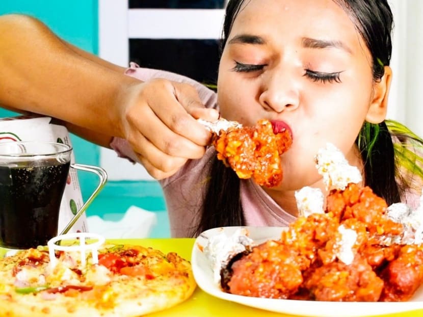 Chicken, omelettes, KFC and noodles — mukbang YouTubers like Deepika Verma (pictured) in India are eating it all as they tackle huge amounts of food in front of an online audience.
