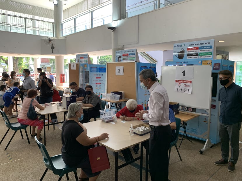 Dr Vivian Balakrishnan speaks to a senior collecting her TraceTogether token at Kampong Kembangan Community Club on Dec 23, 2020.