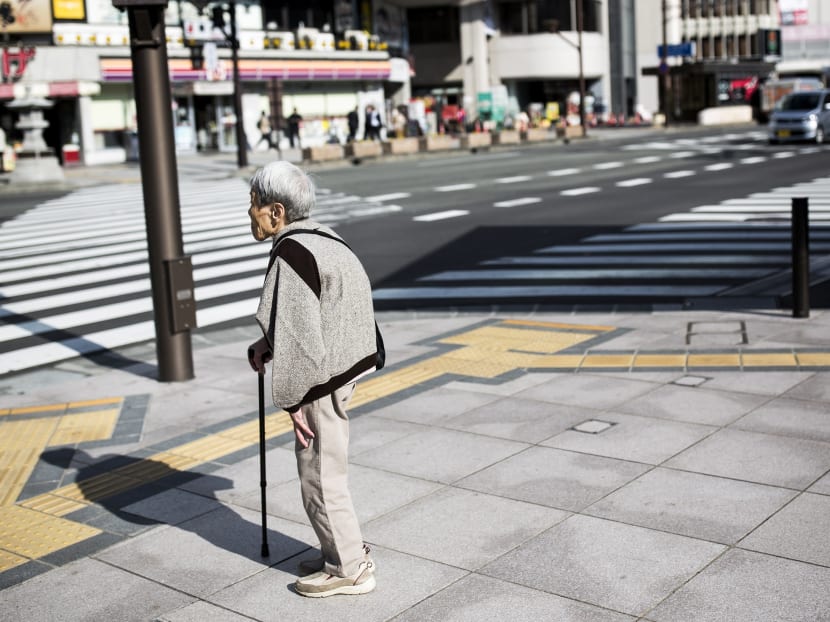 A Japanese elderly woman waits for the traffic light to cross the street in Nagano, northwest of the capital Tokyo on November 7, 2016. Photo: AFP
