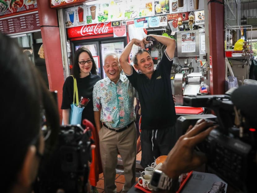 Presidential candidate Ng Kok Song (middle) with his fiancee Sybil Lau, posing for a photo with a stallholder during a walkabout at Ayer Rajah Food Centre on Aug 28, 2023. Presidential candidate Ng Kok Song (middle) with his fiancee Sybil Lau, posing for a photo with a stallholder during a walkabout at Ayer Rajah Food Centre on Aug 28, 2023.