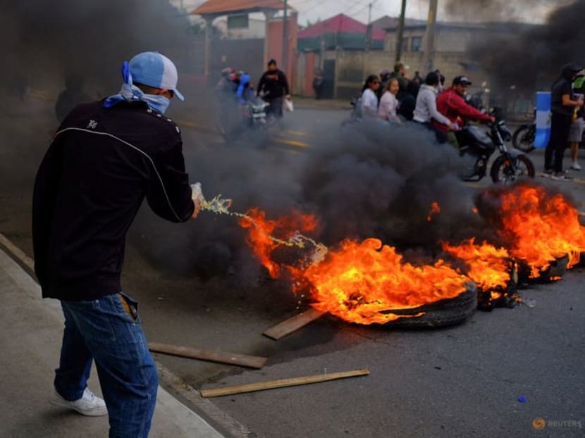 A man pours a liquid on a burning barricade, as part of a national strike to demand the resignation of authorities from the attorney general's office, in Guatemala City, Guatemala October 10, 2023. REUTERS/Josue Decavele/File Photo