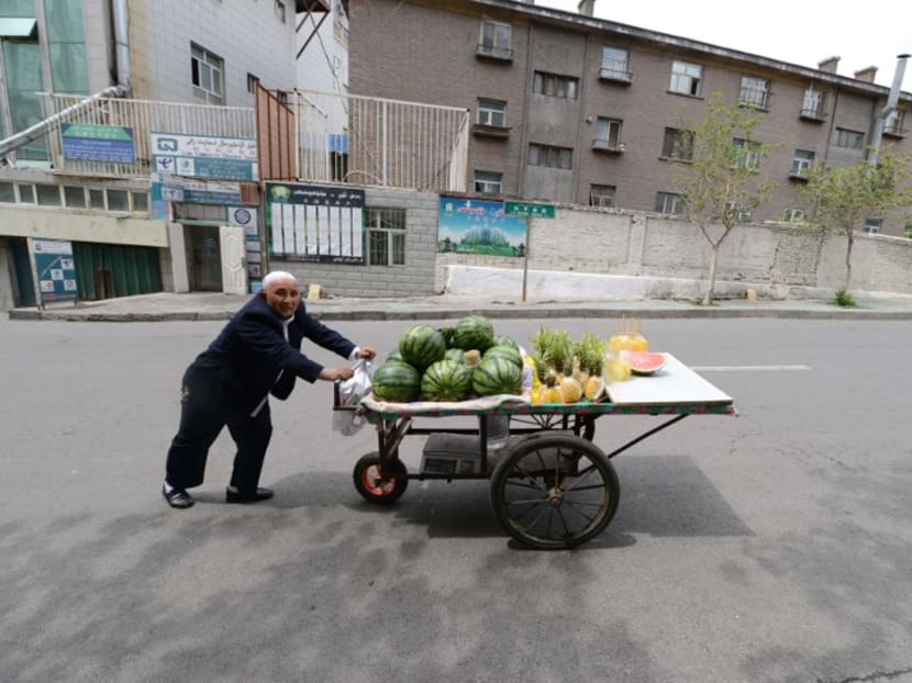 A vendor pushing his cart in Xinjiang's Urumqi. Xinjiang authorities have abruptly cancelled the week-long National Day holiday “to prepare” for the Communist Party congress later this month. Photo: AFP A vendor pushing his cart in Xinjiang's Urumqi. Xinjiang authorities have abruptly cancelled the week-long National Day holiday “to prepare” for the Communist Party congress later this month. Photo: AFP