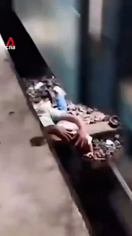 Father in Bangladesh shields child under moving train
