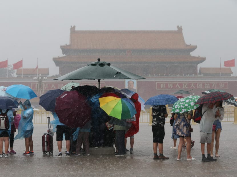 Tourists hold umbrellas as they visit Tiananmen Square during a rainstorm in Beijing, China August 12, 2017. Photo: Reuters
