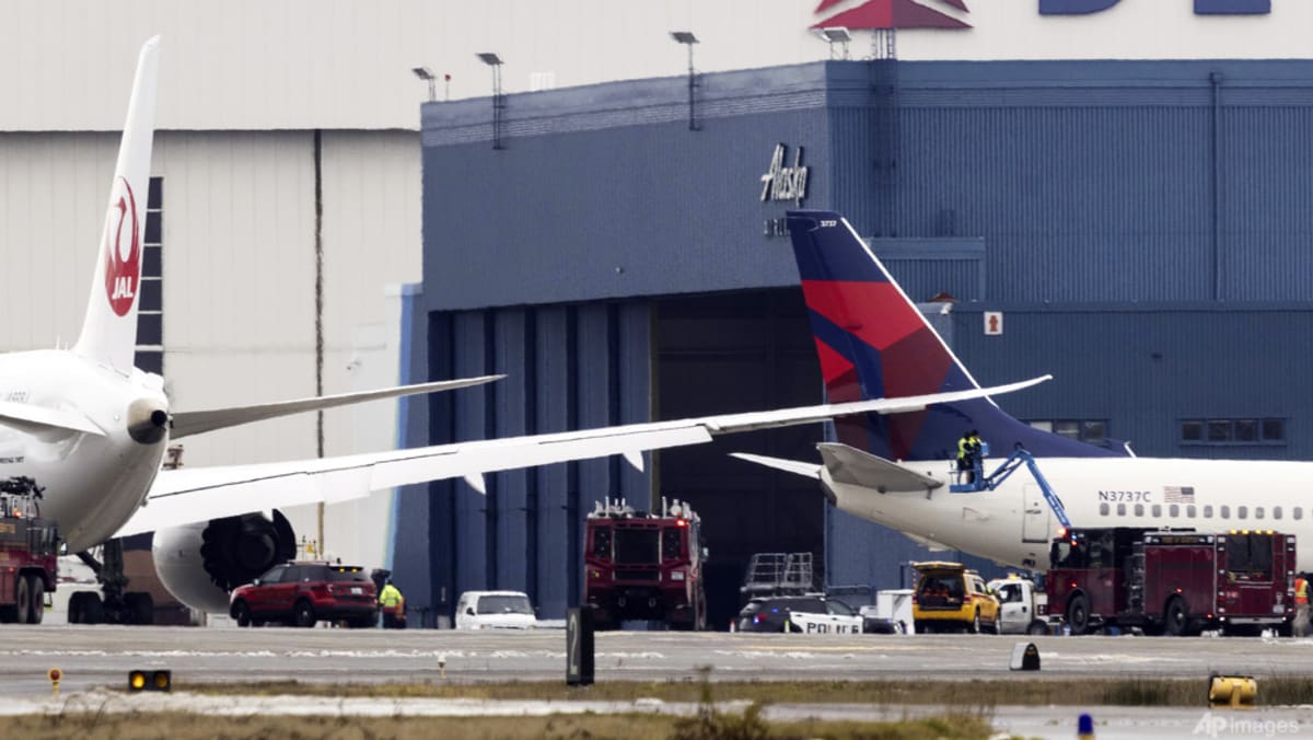 Japan Airlines plane wing clips parked Delta jet at Seattle airport