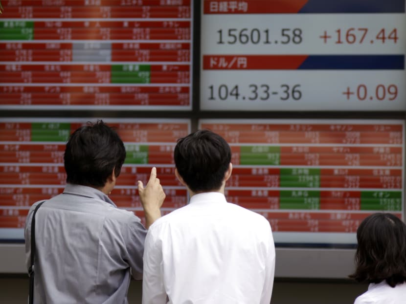 Pedestrians look at an electronic stock board showing Japan's Nikkei 225 index at a securities firm in Tokyo Friday, June 17. Asian stock markets bounced back on Friday, as U.S. consumer price data helped calm investor sentiment, one day after Bank of Japan's decision not to add stimulus measures sparked heavy losses. Investors stayed focused on the next week's referendum on whether Britain would stay in the European Union. Photo: AP