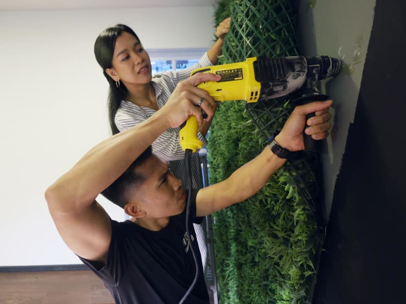 Mr Izwan Firdaus, 38, with his wife Nadirah Baharin, 32, putting up a grass wall by themselves in their home. Mr Izwan Firdaus, 38, with his wife Nadirah Baharin, 32, putting up a grass wall by themselves in their home.