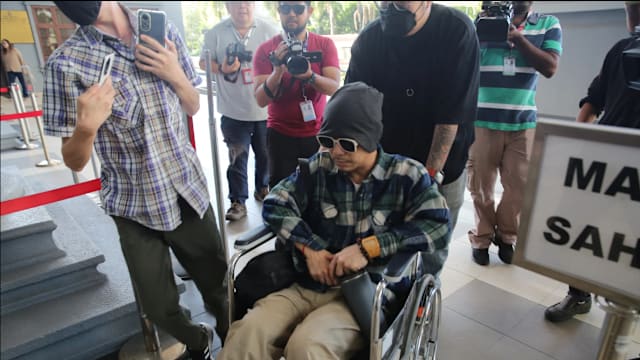 黄明志坐轮椅现身法庭 毒品案获判无罪释放