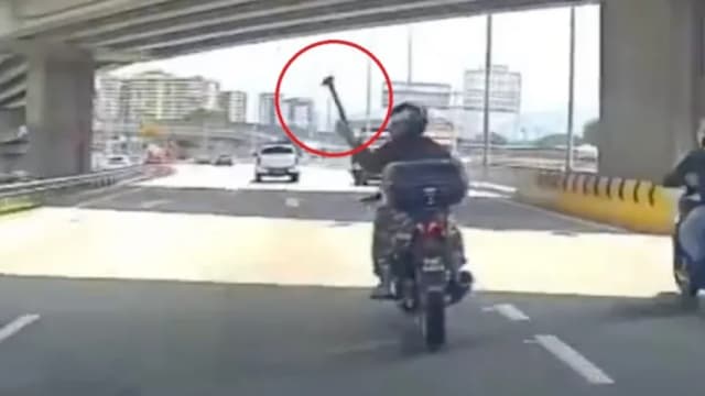 疑不满汽车挡道 摩托车骑士朝车丢铁锤