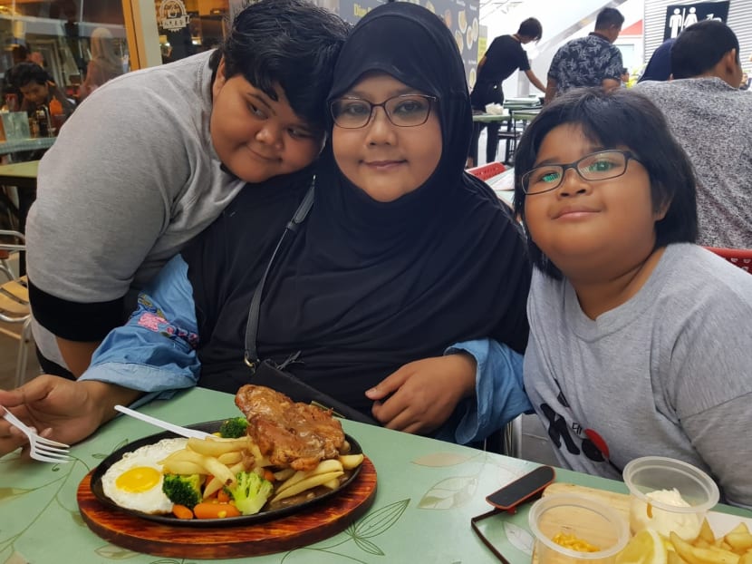 (From left) Nurul Syafiqah, 12, enjoying a meal with her mother Yanti Mazlan, 45, and sister Nuryn Diyana, 10.