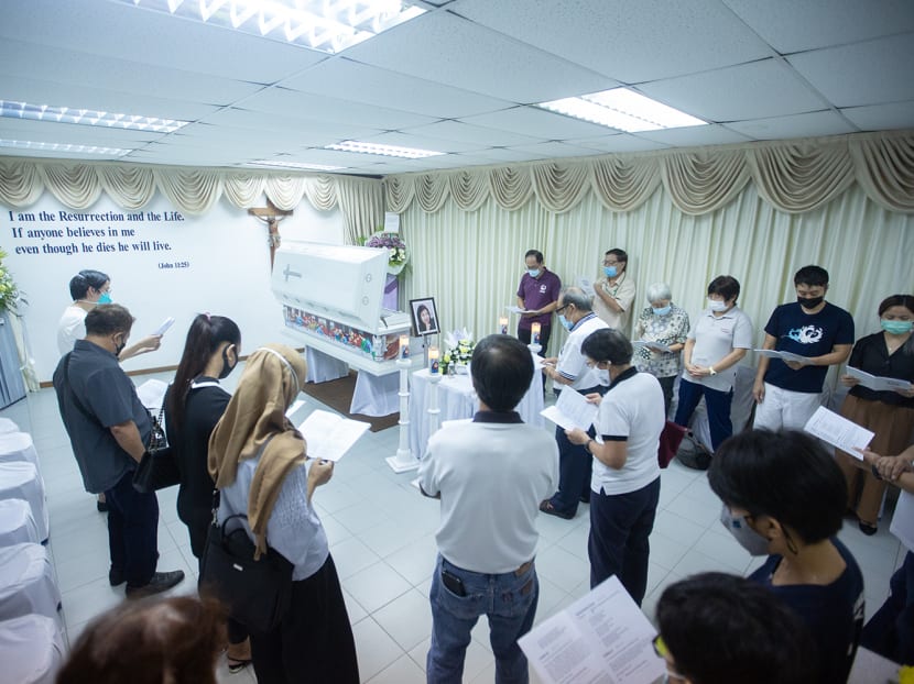 Family and visitors praying at the funeral wake of Home's founder Bridget Tan on April 22, 2022.