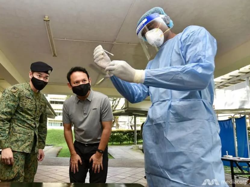 Senior Minister of State for Defence Zaqy Mohamad being briefed on how antigen rapid testing works.