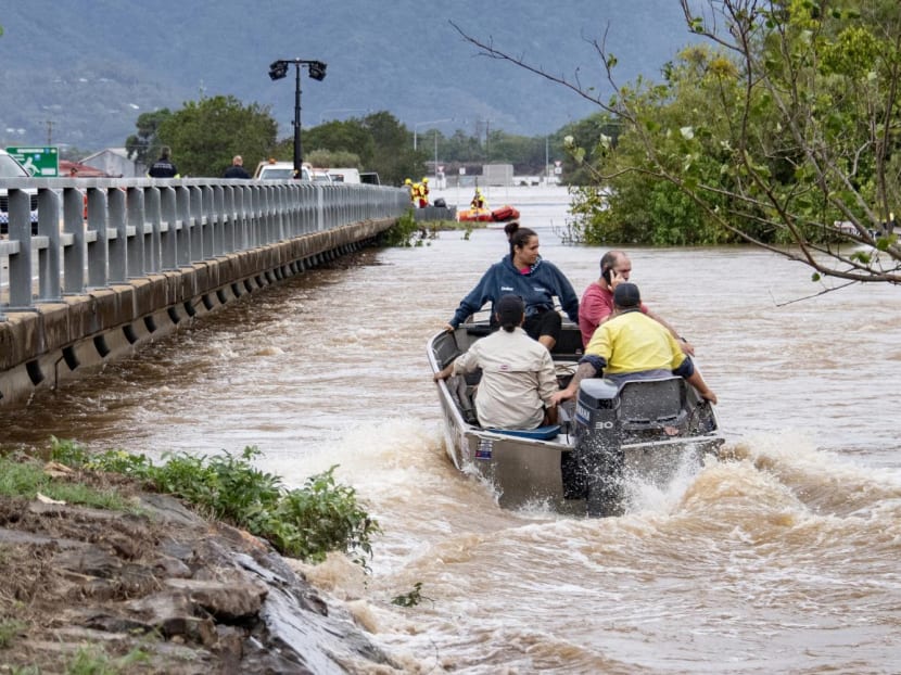 Residents cross floodwaters by boat in Cairns on Dec 18, 2023.