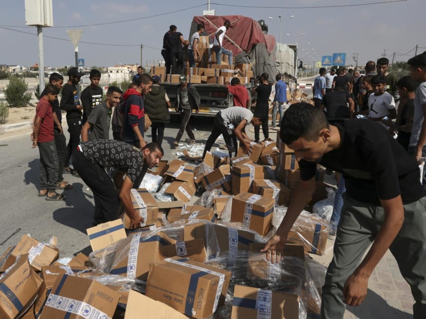 People reload fallen boxes onto a truck carrying humanitarian aid that entered the southern Gaza Strip from Egypt via the Rafah border crossing on Nov 2, 2023, as battles between Israel and the Palestinian Hamas movement continue.